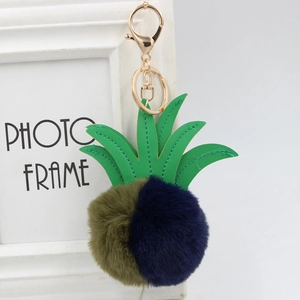 Detailed close-up of faux fur pineapple keychain with green leather leaves and gold clasp