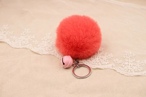 Detail of rose pink faux rabbit fur pom pom keychain with matching small metal bell
