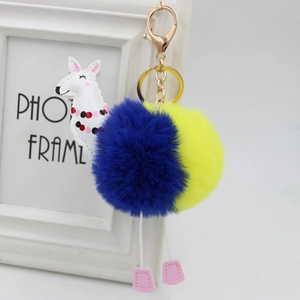 Dettaglio portachiavi alpaca con pompon bicolore e chiusura a moschettone dorata