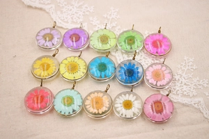 Détail de 15 pendentifs marguerites séchées colorées en verre pour colliers DIY