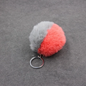 Détail d'un porte-clés pompon bicolore en fausse fourrure avec anneau en métal