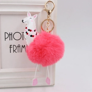 Dettaglio ravvicinato del portachiavi a pompon in pelliccia di alpaca rosa con gancio dorato
