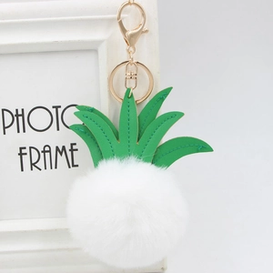 Detail of pineapple faux fur keychain with green PU leather leaves and golden lobster clasp