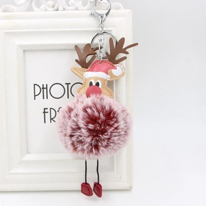 Macro detail of Christmas reindeer plush ball keychain with metal clasp and antler design