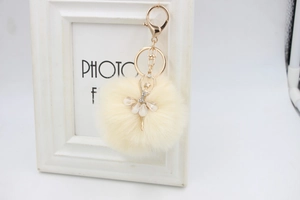 Detail of elegant plush pompom keychain with a rhinestone studded ballerina pendant