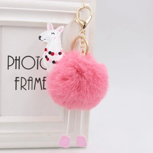Dettaglio portachiavi a forma di alpaca rosa con gancio dorato e morbida palla di pelo