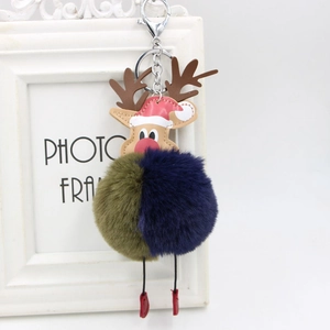 Detailed view of reindeer keychain with two-tone plush ball and festive red hat charm