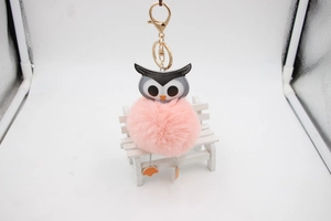 Détail du porte-clés hibou en fourrure rose avec fermoir doré et tête en cuir gris