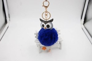 Détail du porte-clés hibou en fausse fourrure bleu marine avec mousqueton doré brillant