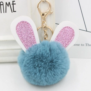 Close-up of sky blue plush rabbit fur ball keychain with pink glitter ears and gold ring