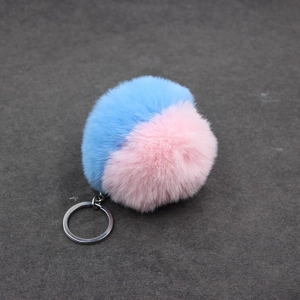 Détail du porte-clés pompon bicolore rose et bleu en fourrure synthétique douce