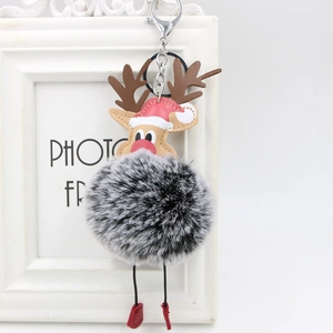 Detail of grey plush reindeer keychain with red Santa hat and festive embroidery on white frame