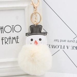 Détail d'un porte-clés bonhomme de neige avec pompon en peluche et fermoir doré