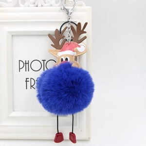 Close-up of a blue reindeer pompom keychain with a red Santa hat and metal ring