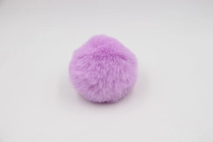 Close-up of a soft purple faux rabbit fur pom-pom ball for bags and DIY crafts