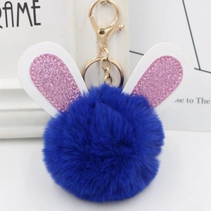 Detailed close-up of blue plush ball keychain with glitter bunny ears and gold lobster clasp