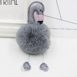Detail of grey plush flamingo keychain showing shiny silver sequins and heart-shaped feet