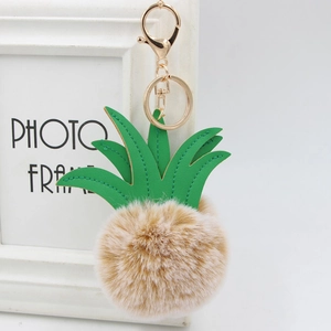 Detailed view of fur pineapple keychain with green PU leather leaves and golden clasp