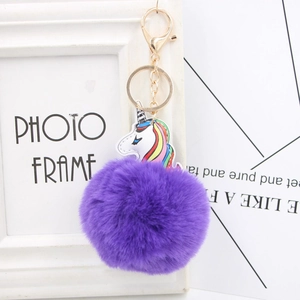 Detailed close-up of purple faux fur pompom keychain with colorful unicorn leather patch