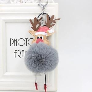 Detail of reindeer plush pom-pom keychain with silver metal lobster clasp and holiday hat