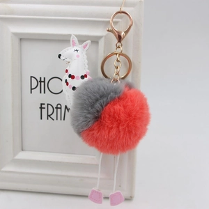 Dettaglio portachiavi alpaca in peluche con pompon e moschettone in metallo dorato