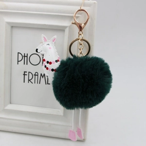 Dettaglio portachiavi con pompon in ecopelliccia verde scuro e ciondolo alpaca con gancio oro