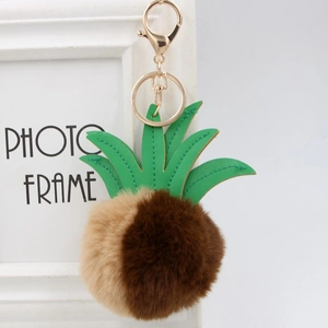 Detail of faux fur pineapple keychain with PU leather leaves and golden metal lobster clasp
