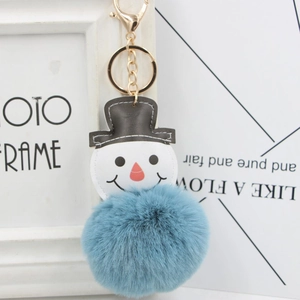 Détail du pompon en fausse fourrure bleue et charme bonhomme de neige sur porte-clés
