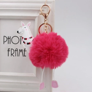 Dettaglio portachiavi pompon rosa acceso con ciondolo alpaca bianco e gancio oro rosa