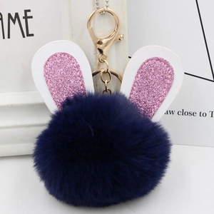 Detail of navy blue faux fur rabbit ear keychain with pink glitter and gold hardware