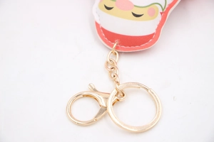 Close-up of golden lobster clasp and flat ring with festive Santa Christmas keychain