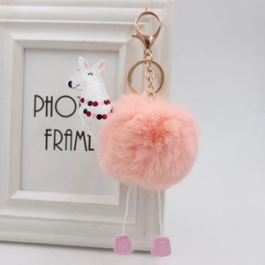 Dettaglio ravvicinato di un portachiavi a pompon rosa a forma di alpaca con fibbia oro