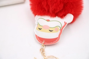 Detail of red faux fur pompom and cartoon lion charm with golden chain keychain