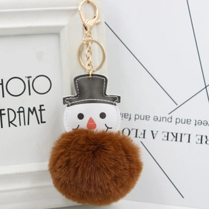 Gros plan d'un porte-clés bonhomme de neige avec pompon en fausse fourrure marron.