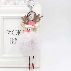 Detailed close-up of a pink reindeer plush pompom keychain with a red Santa hat