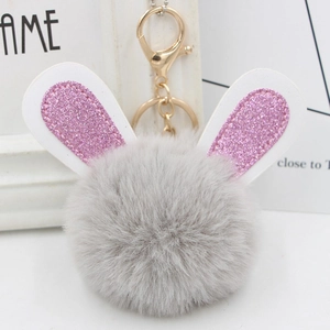 Detail of plush bunny keychain with grey fur pompom and pink glitter ears