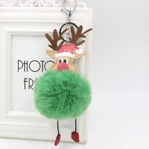 Close-up of a festive Christmas reindeer keychain with green faux fur pompom and red boots