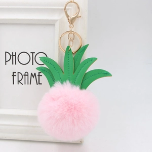 Detail of pink faux fur pineapple keychain with green leather leaves and gold clasp