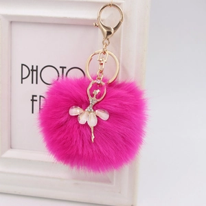Close-up of fluffy rose pink pom-pom keychain with rhinestone ballet dancer charm