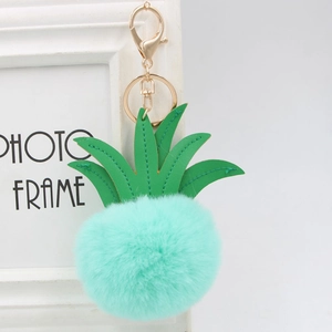 Close-up of mint green fur pompom pineapple keychain with gold lobster clasp