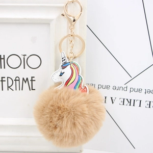 Detailed view of unicorn PU leather charm with soft khaki faux fur pompom and gold keychain