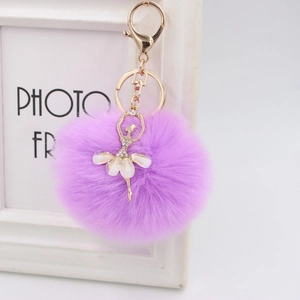 Detail of soft purple faux fur pompom keychain with a sparkling rhinestone ballet girl charm