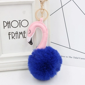 Close-up of plush flamingo keychain with navy faux fur ball and golden metal ring