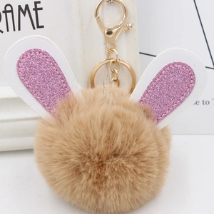 Detailed macro view of bunny ear pompom keychain with brown fur and glittery details
