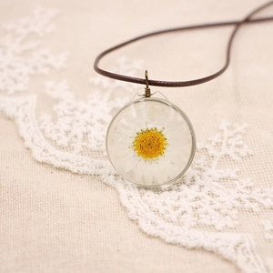 Vue détaillée d'une véritable marguerite conservée dans un pendentif en résine claire