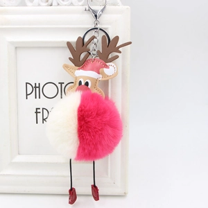 Close-up of reindeer plush ball keychain with red hat and leather head for bags