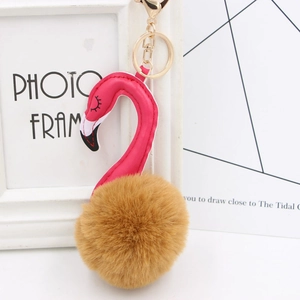 Detail of plush flamingo keychain with gold metal ring and pink faux leather head