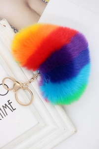 Close-up of heart-shaped rainbow faux fur keychain with golden clasp and fluffy texture