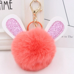 Detail of coral pink fluffy rabbit ear keychain with sparkling glitter ears and gold clasp
