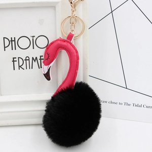 Detail view of flamingo keychain with black faux fur pompom and golden lobster clasp